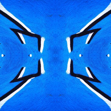 two pronged fork design in black and white against a vivid royal blue a textured wall transformed into intricate patterns by reflection and twistingの写真素材