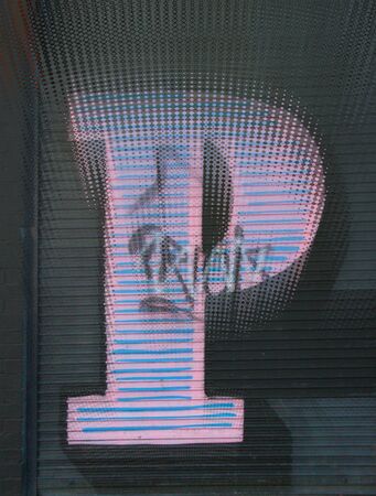 closeup ripple effect of huge capital letter P  in silver paint on shutter doors on a dark background into shapes patterns and intricate designsの写真素材