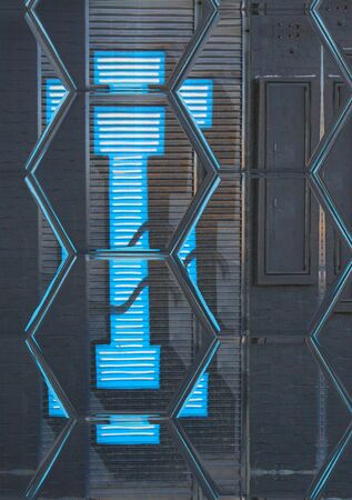 closeup of hexagonal mosaic view of huge capital letter I  in blue paint on shutter doors on a dark background into shapes patterns and intricate designsの写真素材