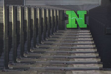 diminishing perspective concentric effect of huge capital letter N  in green paint on shutter doors on a dark backgroundの写真素材