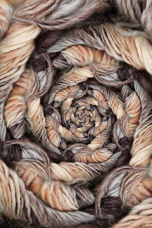 beige and brown skein of wool on a plain black background