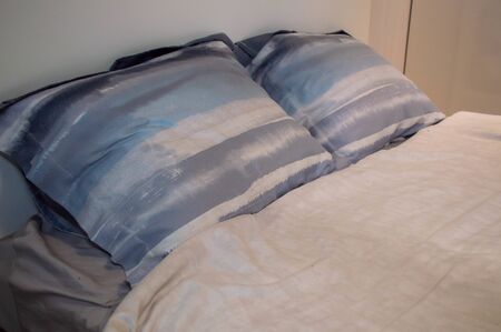 Pillows are on the bed in the bedroom.の写真素材