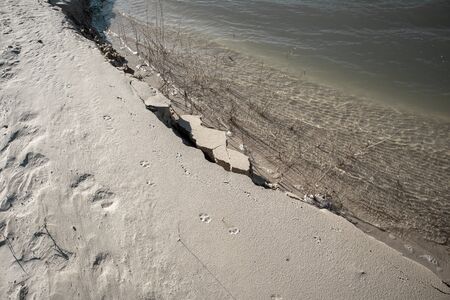 Small waves on blue water and a sandy beach. Pond on a sand quarry.の写真素材