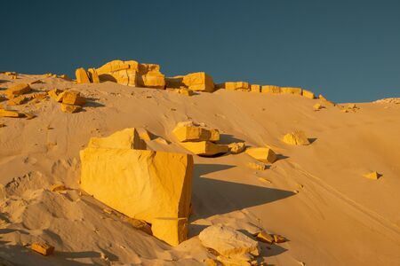 Big stones in the desert. Yellow sand on a background of blue sky.の写真素材