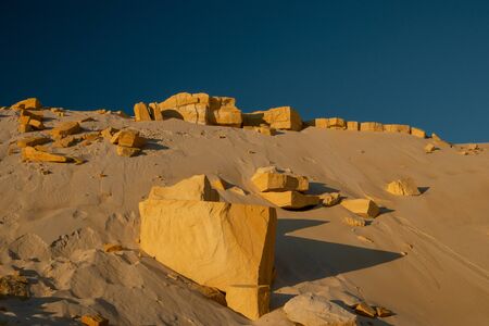 Big stones in the desert. Yellow sand on a background of blue sky.の写真素材