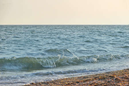 Beach on a Sunny summer day during sunset. Landscape with sea sunset on beach. The sea wave came...
