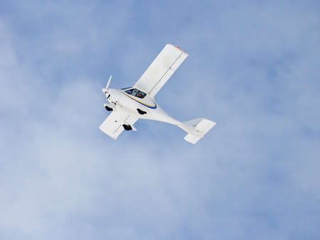 Zoom photo of small propeller airplane landing to small airport.