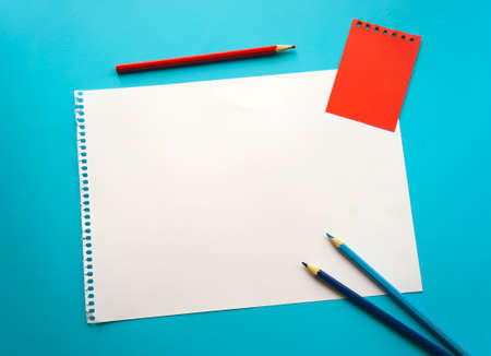 Blank sheet of paper space for design and lettering on a beautiful blue background, blue pencils. A...