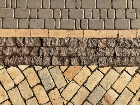 Yellow stone tiles masonry closeup background. the texture of yellow antique paving stones. Old...