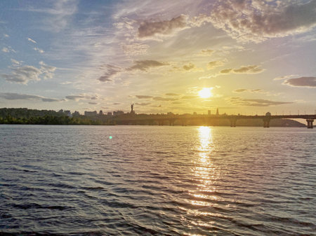 Historical sights of Ukraine. Beautiful scenic view of Kyiv. Sunset over the Dnieper River in Kiev. View of the river with waves. Dramatic colorful sunset over Dnipro river in Kiev, Ukraine, travelの写真素材