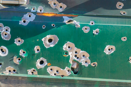 bullet holes in the metal. multiple bullet marks on the car body. peeling green bullet holes, texture, metal, shooting, shooting on the street, shot, target, bullet, grapeshot, gunpowder, backgroundの写真素材
