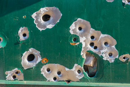bullet holes in the metal. multiple bullet marks on the car body. peeling green bullet holes, texture, metal, shooting, shooting on the street, shot, target, bullet, grapeshot, gunpowder, backgroundの写真素材