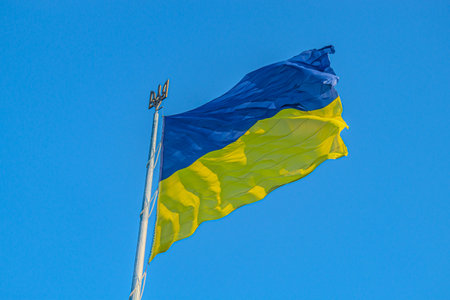 Emblem of Ukraine. Ukraine flag large national symbol fluttering in blue sky. Large yellow blue...
