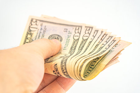 Several 50 dollar bills in hand. Man hand with dollars isolated on a white background. Businessman...