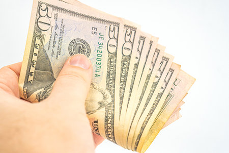 Several 50 dollar bills in hand. Man hand with dollars isolated on a white background. Businessman...