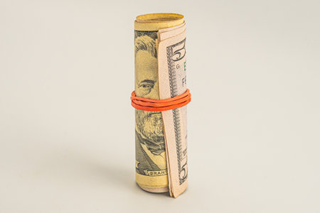 Banknotes of the United States dollar. Roll of fifty US dollars isolated on a white background. Dollar roll isolated on white backgroundの写真素材