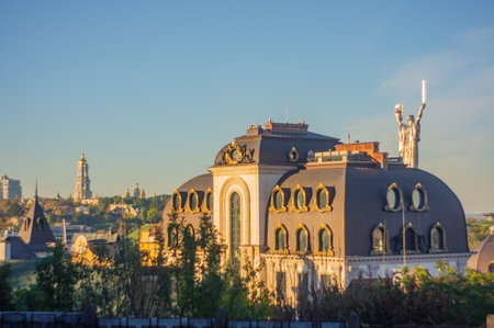 Image of a grand, ornate building with balconies and windows in an urban park setting The structure has a domed roof and is part of a larger cityscape Soft shadows suggest early morning or late aftの写真素材