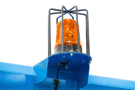 Close-up of a bright orange light fixture with clear cover, mounted on a blue metal structure...