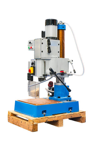 Steel industrial machine on wooden pallets in an industrial facility, with a control panel,...