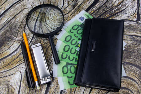 Financial, business success or analysis concept with 100 Euro bills fanned below a purse with...