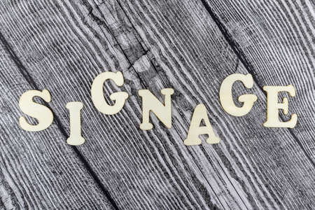 Signage concept with design template on old diagonal wooden boards and alphabet letters in a wavy line with copyspace above and belowの写真素材