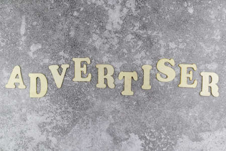 Advertiser concept with decorative alphabet letters in an undulating line on a textured grey background viewed as a flat lay with copyspaceの写真素材