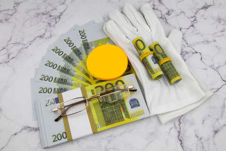 Financial or business concept with a pair of white gloves, eyeglasses and wads and fanned 200 Euro...