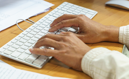Closeup of a male hands busy typing on a keyboard computer. technology concept. office concept.の写真素材