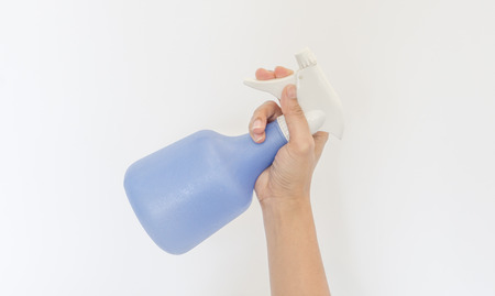 Spraying a cloth with laundry detergent in spray bottle on hand.の写真素材