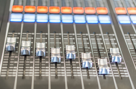Selective focus buttons equipment for sound mixer control with blurry background., in live studio...