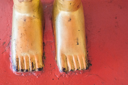 Gold foot of Buddha statue on red backgroundの写真素材