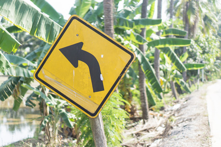 Left turn Sign, Road sign warns of a turn left, Old yellow traffic sign symbol turn left on the road.の写真素材