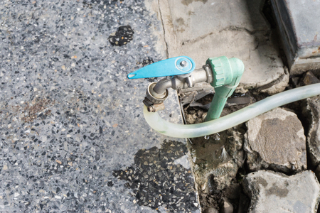 Garden hose or white rubber tube with faucet on grass field.の写真素材