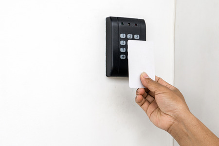 Door access control - young woman holding a key card to lock and unlock door., Keycard touch the...