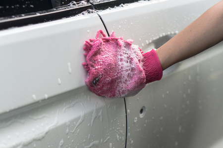 hand hold sponge over the car for washingの写真素材
