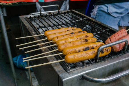 Thai Meat Balls and Hot Dogs in grilling process at the market.の写真素材