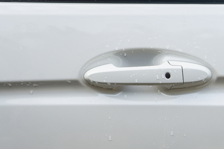 White car door handle with water drop abstract background., Handle of a white car door in rainy dayの写真素材