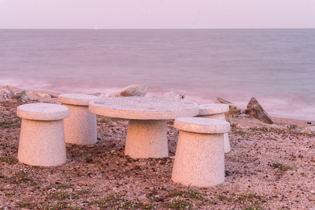 Marble table and chair on the sand., Evening day at the sea. relax time., with copy space for text.の写真素材