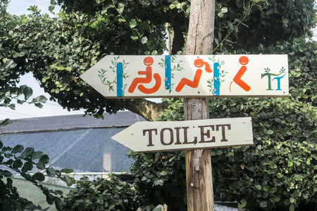 Wooden sign toilet restroom male and female and handicap with arrow show direction on nature background., holiday concept.の写真素材