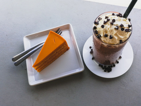 Ice coffee and milk tea crepes cake on wooden table in cafe close to river., bangkok thailand. holiday concept.の写真素材