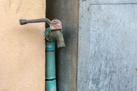 Water faucet with grass at outdoor house., texture background