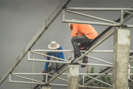 In the construction site, the welding workers at work., worker weld metal in factory and sparksの写真素材