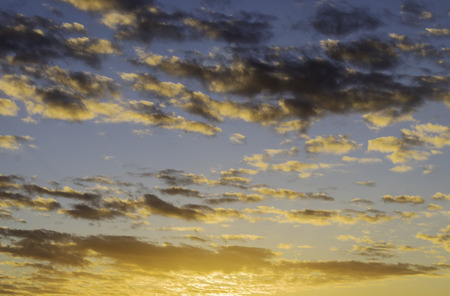 Dramatic sunrise with orange and blue sky and black clouds
