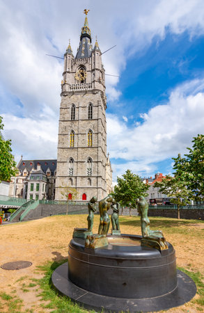 Gent, Belgium - June 2019: Fountain of Kneeling Youths with Belfort tower at backgroundのeditorial素材