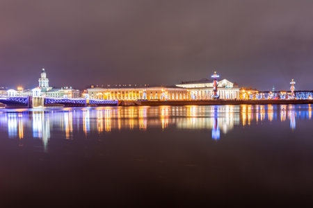 Spit (Strelka) of Vasilyevsky island with Rostral columns, Kunstkamera museum and Palace bridge at night during New Year and Christmas holidays, Saint Petersburg, Russiaのeditorial素材