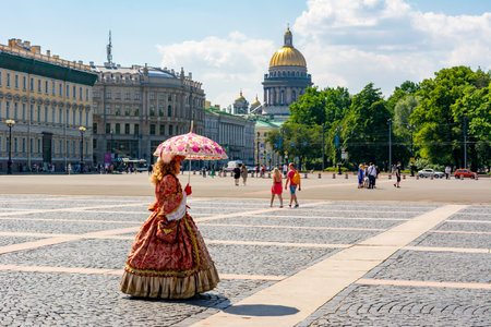 Saint Petersburg, Russia - June 2021: Woman dressed as queen on Palace square with St. Isaac's cathedral at backgroundのeditorial素材