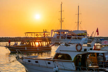 Side, Turkey - September 2021: Ships and boats in Side port at sunset