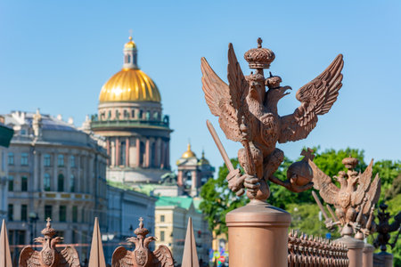 Sculptures of eagles at Alexander column on Palace square with St. Isaac's cathedral at background, Saint Petersburg, Russiaのeditorial素材