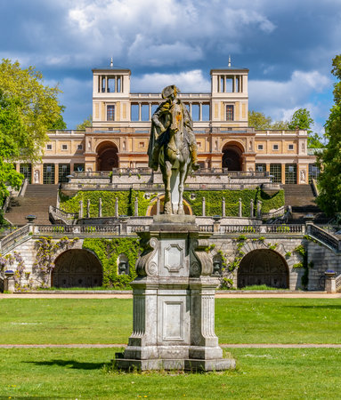 Frederick the Great monument with Orangery at background in Sanssouci park, Potsdam, Germany