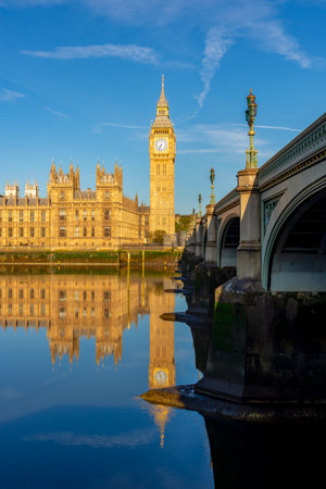 Houses of parliament with Big Ben tower and Westminster bridge reflected in Thames river, London, UKの写真素材